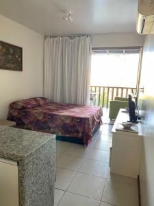 a bedroom with a bed and a window and a desk at Nannai Residence -Muro Alto/PE in Porto De Galinhas