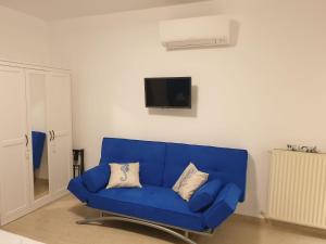 a blue couch in a living room with a tv at L'approdo in Bordighera
