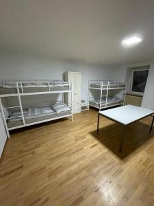 a room with three bunk beds and a table at Schlaffburg in Klosterneuburg