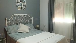 een slaapkamer met een wit bed en een wit kussen bij Vivienda Rural El Retorno in Sevilla