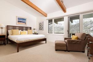 um quarto com uma cama, uma cadeira e janelas em Deluxe 3 Bedroom - Aspen Alps #508 em Aspen