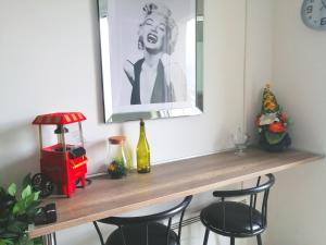 a wooden table with chairs and a picture on the wall at Le 1965 Double BALNEO, confort et romantique in Grenoble +17 photos