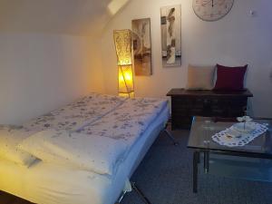 - une chambre avec un lit, une table et une horloge dans l'établissement Ferienwohnung Kunterbunt, à Winterberg