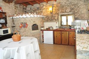 a kitchen with a white table in a stone kitchen at Quinta das Eiras in Penela
