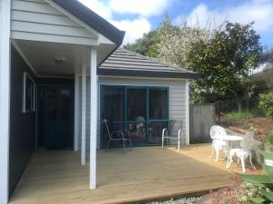 une terrasse avec une table et des chaises. dans l'établissement Observation Holiday Home, à Paraparaumu Beach
