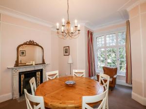 a dining room with a wooden table and a fireplace at Lewarne in Boscastle