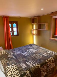 a bedroom with a bed with a quilt on it at Hostal Corvatsch in San Pedro de Atacama