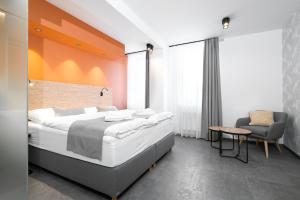 een slaapkamer met een groot bed en een stoel bij Hotel Diana in Karviná