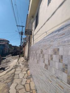 eine Backsteinmauer neben einer Straße neben einem Gebäude in der Unterkunft Montanha Mágica Hospedagens in São Thomé das Letras