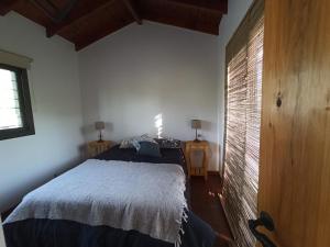 Un dormitorio con una cama y una pared de ladrillo. en Papa Ruku, en Villa Ciudad Parque