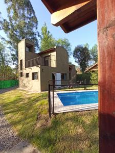 una casa con piscina delante en Papa Ruku, en Villa Ciudad Parque