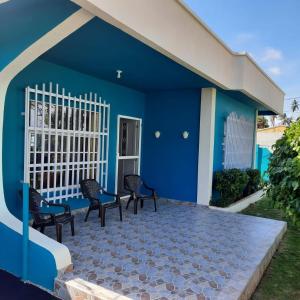 una casa azul con sillas en un patio en Posada Nativa Miss Nova, en San Andrés