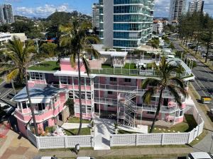 an aerial view of a pink building with palm trees at The Pink Hotel Coolangatta in Gold Coast