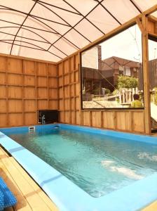 a swimming pool in a wooden building with a large window at Cabañas Paidahue Pichilemu in Pichilemu
