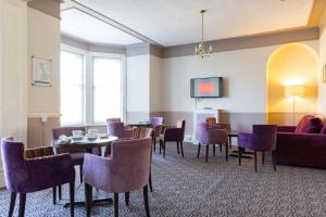 a dining room with purple chairs and a table at Dilkhusa Grand Hotel by Compass Hospitality in Ilfracombe