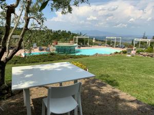 a table and chairs in front of a pool at Villa Le Polle di Meletro in Chianni