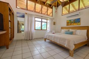 ein Schlafzimmer mit einem großen Bett und einem großen Fenster in der Unterkunft Casa Sueca Hotel - At the Beach in Tamarindo