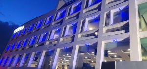 un bâtiment avec des lumières bleues sur son côté dans l'établissement Best Western Plus Metepec & Suites, à Toluca