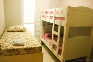 1 dormitorio con 2 literas y 1 cama en Apto 2 dormitórios à 400 m da Praia de Riviera de São Lourenço - com serviço de praia, en Bertioga