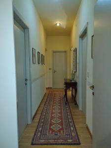 pasillo con alfombra, puerta y mesa en Villa Carol Appartamento e B&B, en Tollo