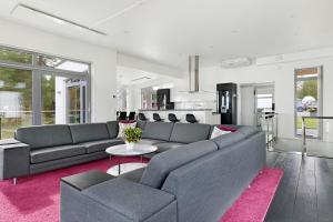 ein Wohnzimmer mit einem Sofa und einem Tisch in der Unterkunft Luxury modern 5BR beach House for Weekend Getaways near Piteå in Piteå