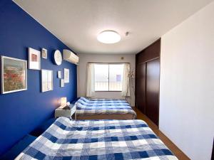 2 łóżka w pokoju z niebieskimi ścianami w obiekcie 松戸駅ｽｸﾞ 1DK 出張に旅行に Nomad松戸宿019 w mieście Matsudo