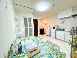 a dining room with a table and a kitchen at 松戸の快適ロフトベッド1DK 長期滞在にも Nomad松戸宿005 in Matsudo