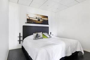 a bedroom with a white bed with a cross on the wall at Luxury modern 5BR beach House for Weekend Getaways near Piteå in Piteå