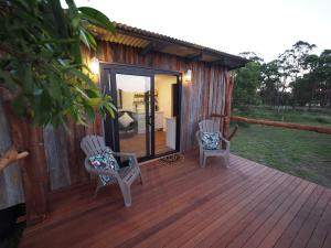 a deck with two chairs and a house at Straw House Farm B&B in Dalveen