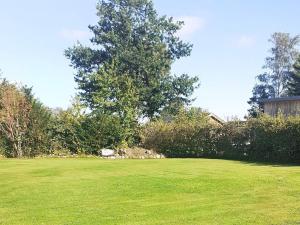 een groen veld met een boom en een huis bij 5 person holiday home in Odder in Odder