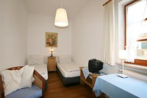 オーバーアマガウにあるHotel-Gasthof Roseのベッド、ソファ、テレビが備わる客室です。