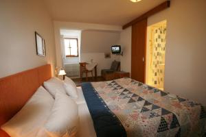 a bedroom with a bed with a quilt on it at Hotel-Gasthof Rose in Oberammergau