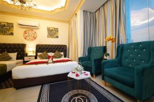 a bedroom with a bed and two blue chairs at Ghazrin's Classic in Johor Bahru
