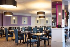 un ristorante con tavoli, sedie e pareti viola di The Caledonian Torbay Hotel a Torquay