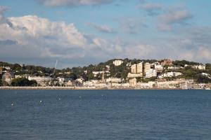 a large body of water with a city in the background at The Caledonian Torbay Hotel in Torquay +14 photos