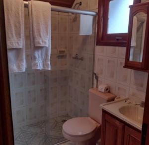 uma casa de banho com um WC e um lavatório em Pousada Chales Monte Verde em Monte Verde