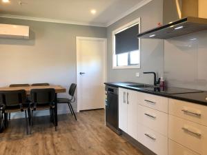 a kitchen with a table with chairs and a counter top at Central, Cosy, Convenient in Twizel