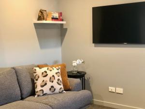 a living room with a couch and a flat screen tv at Central, Cosy, Convenient in Twizel