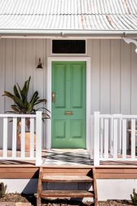 a green door on the front of a house at Mill Cottage in Tenterfield