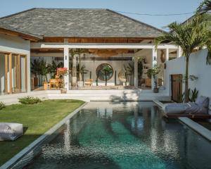 una casa con piscina delante de una casa en MODJO Villas Bingin, en Uluwatu