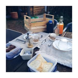 a picnic table with bread and containers of food on it at BorgoGuerzano77 in Camugnano