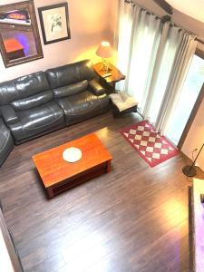 a living room with a leather couch and a table at 106 Village at Camelback in Tannersville