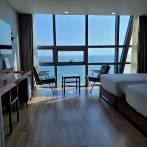 a bedroom with a bed and a view of the ocean at MS Hotel Haeundae in Busan