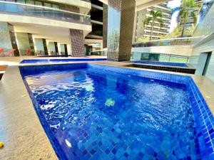 a swimming pool with blue tiles in a building at LANDSCAPE SOLAR - Beira Mar de Fortaleza in Fortaleza +44 photos
