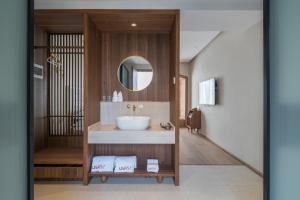 Lisa's Hotel في يانغتشو: حمام مع حوض ومرآة