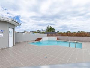 a swimming pool in the middle of a patio at Barefoot Bliss 4 in Fingal Bay