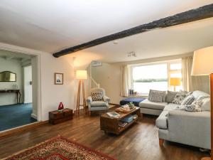 uma sala de estar com um sofá e uma mesa em Clamoak Cottage em Yelverton