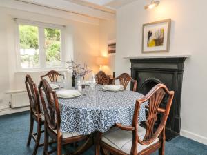 a dining room with a table and chairs and a fireplace at Clamoak Cottage in Yelverton