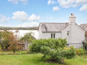 a white house with a view of the water at Clamoak Cottage in Yelverton