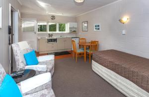 1 dormitorio con 1 cama y cocina con mesa en Brookby Motel en Thames